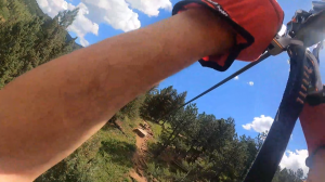 Guide helping a zipliner on a wooded platform