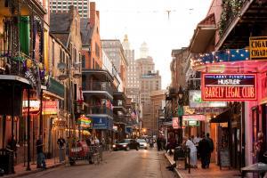 Bourbon Street in New Orleans with bars and revelers