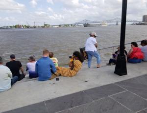 People walking along the New Orleans Riverwalk with a view of the city