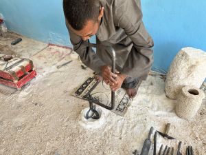 An artisan carving a piece of alabaster stone in Luxor