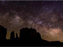 A night sky full of stars above the Sedona landscape