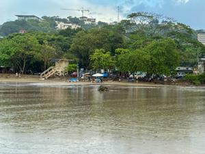 Surfers walking along Tamarindo Beach